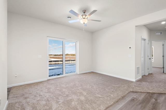 unfurnished room with ceiling fan and carpet