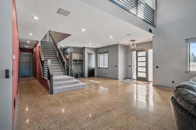 entrance foyer featuring baseboards, speckled floor, and plenty of natural light