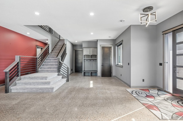 entryway with baseboards, stairs, and recessed lighting