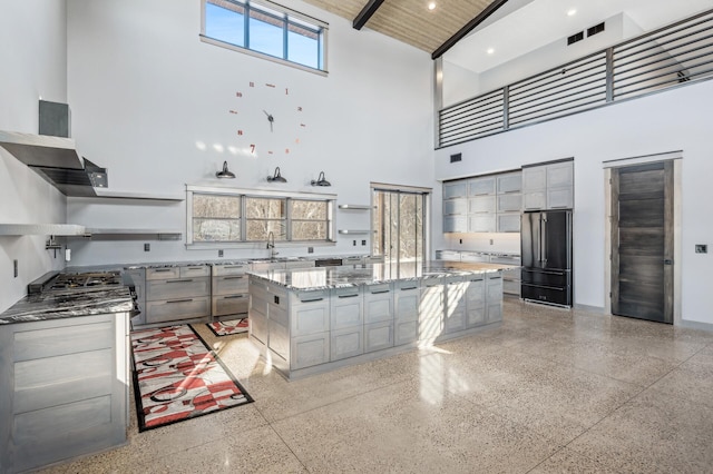 kitchen featuring light speckled floor, high vaulted ceiling, high quality fridge, and open shelves