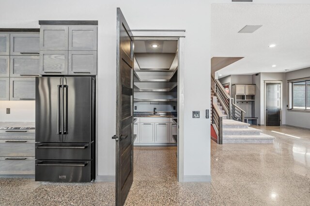 kitchen with baseboards, high end fridge, and light speckled floor