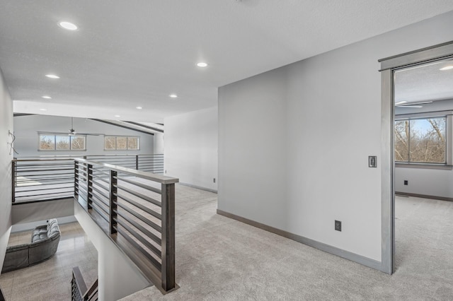 hallway featuring carpet flooring, an upstairs landing, baseboards, and recessed lighting