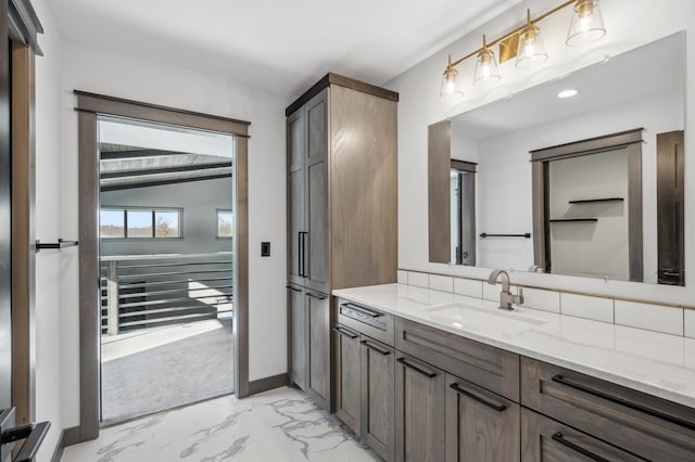 bathroom with baseboards, marble finish floor, and vanity