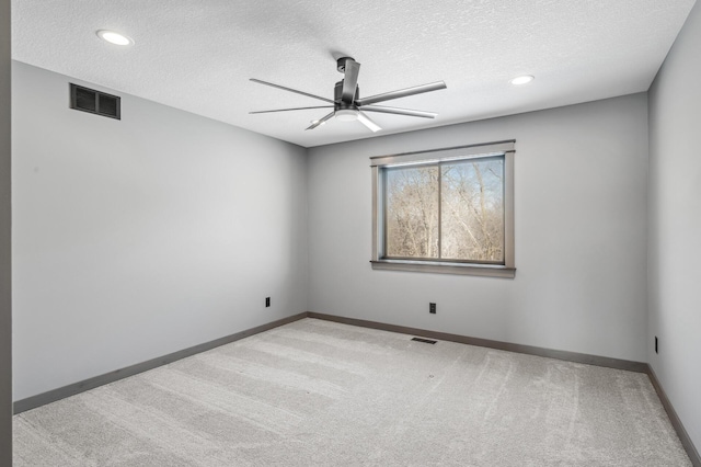 empty room with baseboards, carpet flooring, ceiling fan, and visible vents