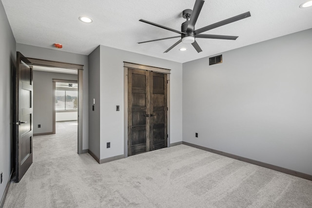 unfurnished bedroom featuring recessed lighting, baseboards, light colored carpet, and visible vents