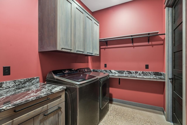 laundry room featuring cabinet space, baseboards, and separate washer and dryer