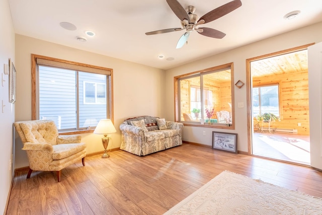 living area with ceiling fan and light hardwood / wood-style floors