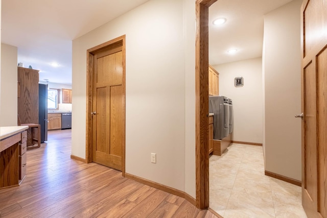 hallway featuring light hardwood / wood-style floors and washer and dryer