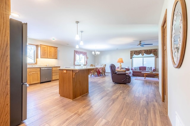 kitchen with light wood finished floors, open floor plan, appliances with stainless steel finishes, and a kitchen breakfast bar