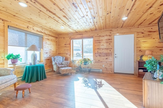 living area with wood ceiling, wood finished floors, baseboard heating, recessed lighting, and wooden walls