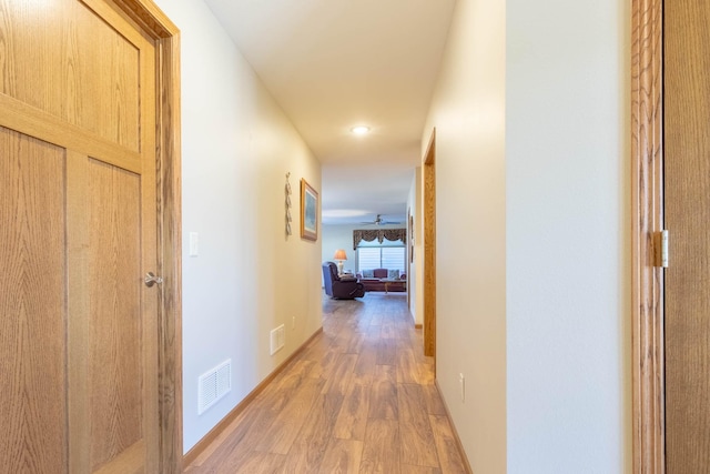 hallway featuring light wood-style flooring, recessed lighting, and baseboards