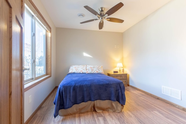 bedroom featuring light wood-type flooring, baseboards, and a ceiling fan