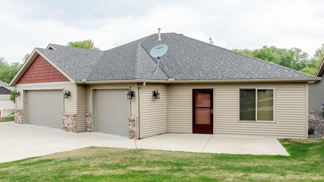 932 Oak Pond Ct, Sartell, MN 56377 - back of house featuring roof with shingles, a garage, driveway, and a yard