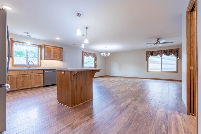 932 Oak Pond Ct, Sartell, MN 56377 - kitchen featuring appliances with stainless steel finishes, a kitchen breakfast bar, brown cabinets, open floor plan, and recessed lighting