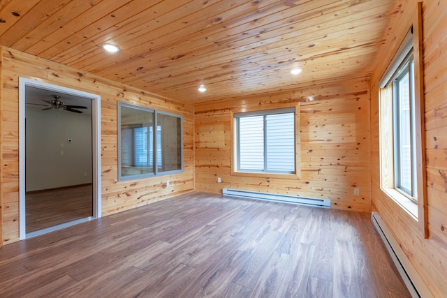 932 Oak Pond Ct, Sartell, MN 56377 - spare room with a baseboard radiator, wood walls, wood finished floors, wood ceiling, and healthy amount of natural light