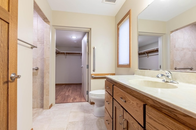 932 Oak Pond Ct, Sartell, MN 56377 - bathroom with vanity, a spacious closet, toilet, and tile patterned flooring