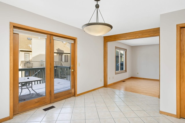 unfurnished room with french doors and light tile patterned floors