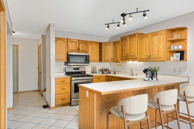 kitchen with sink, a kitchen breakfast bar, kitchen peninsula, and appliances with stainless steel finishes