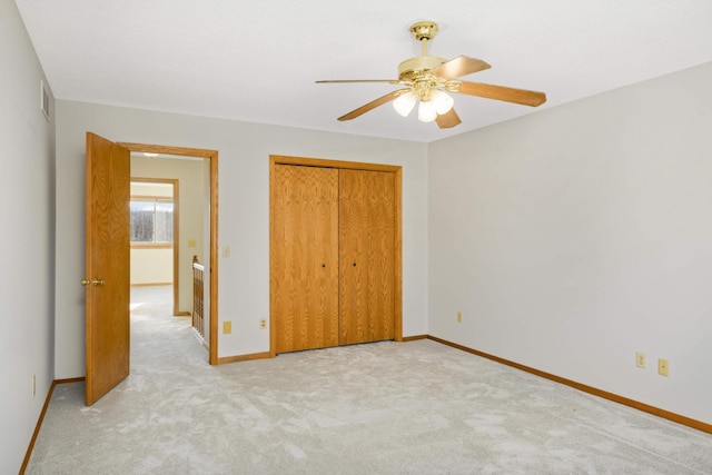 unfurnished bedroom with light carpet, ceiling fan, and a closet