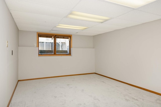 empty room featuring carpet floors and a paneled ceiling