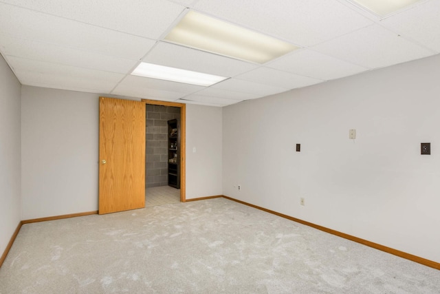 spare room with a paneled ceiling and carpet flooring