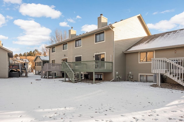 snow covered house with a wooden deck and central AC