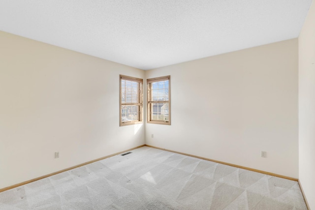 carpeted spare room featuring a textured ceiling