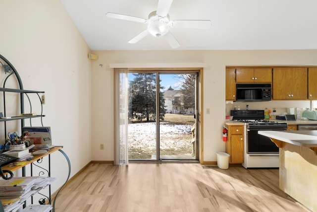 kitchen with dishwasher, range with gas cooktop, light hardwood / wood-style floors, and ceiling fan