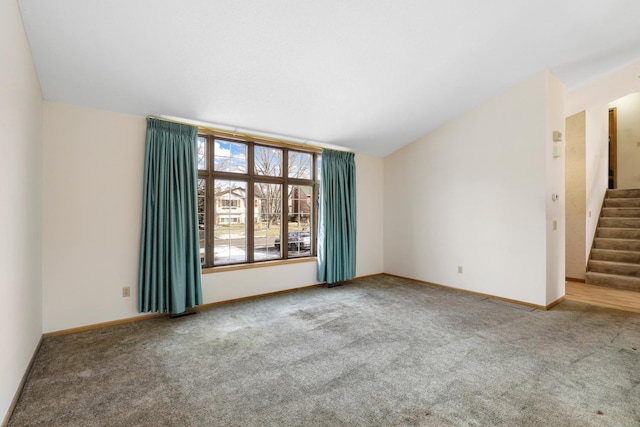 carpeted empty room featuring lofted ceiling