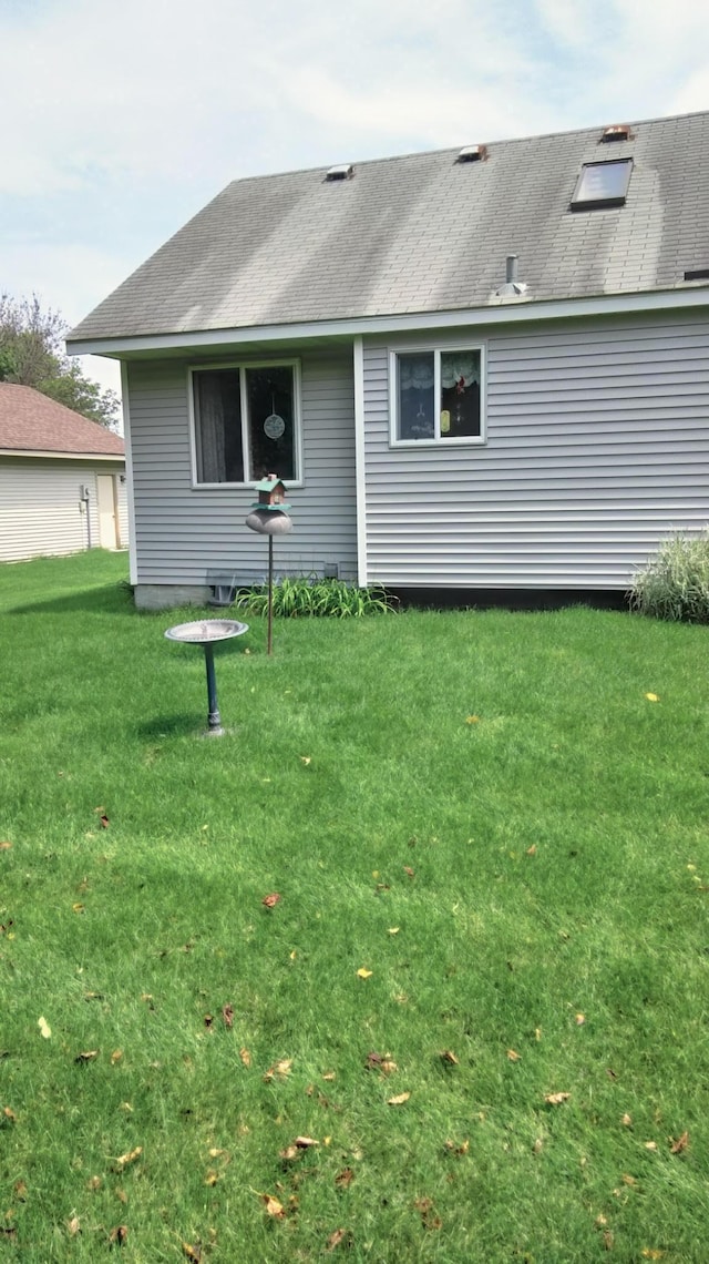 rear view of house featuring a yard