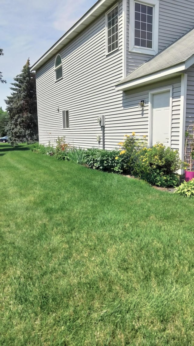 view of side of home with a yard