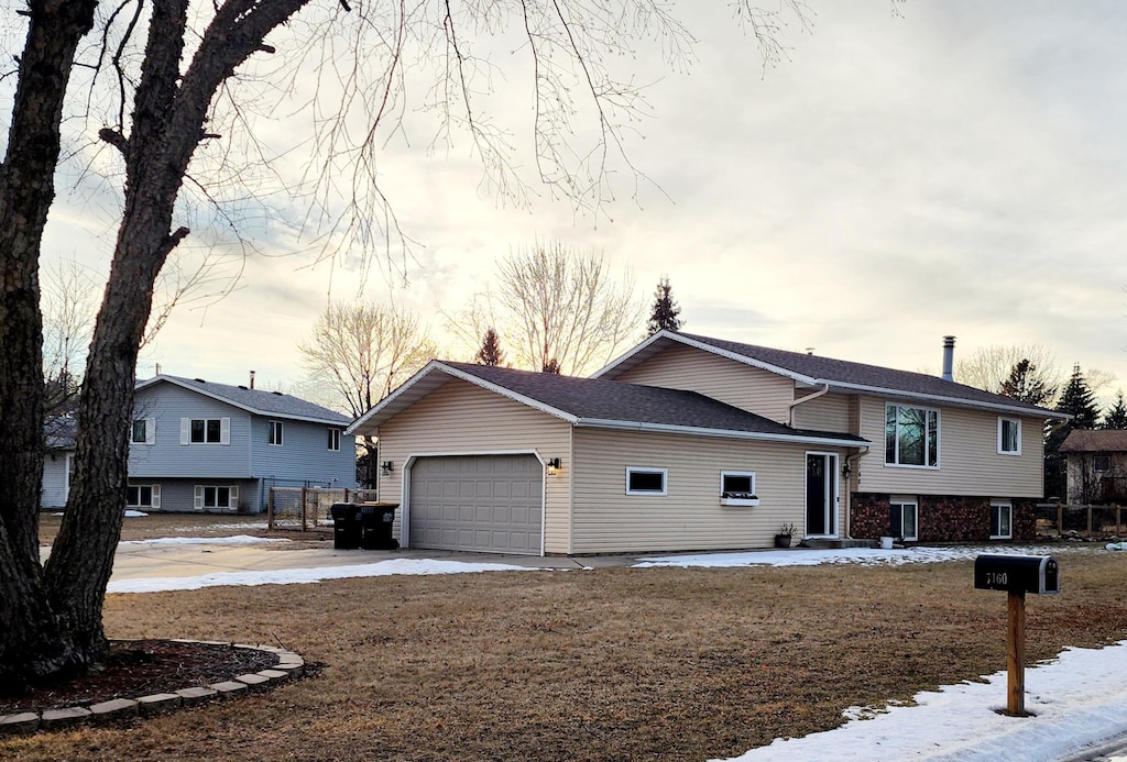 split level home with a garage and concrete driveway