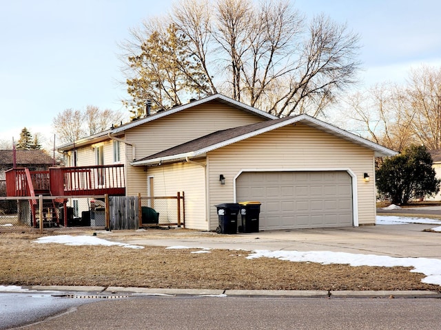 view of side of property featuring a garage and a wooden deck