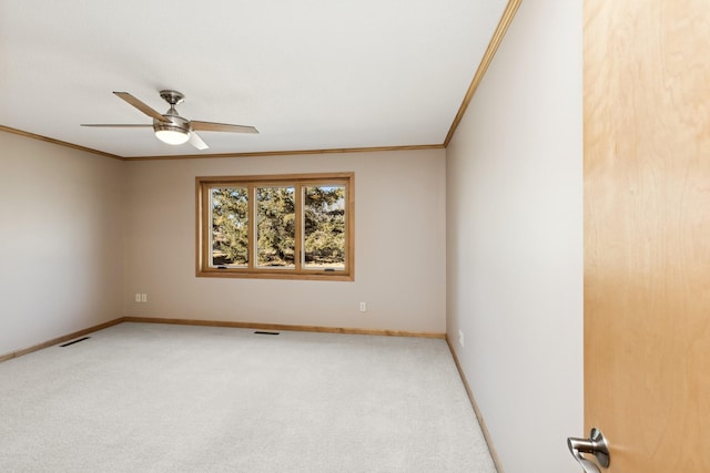 unfurnished room with light carpet, baseboards, ornamental molding, and a ceiling fan