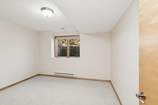 carpeted spare room with a baseboard radiator and baseboards