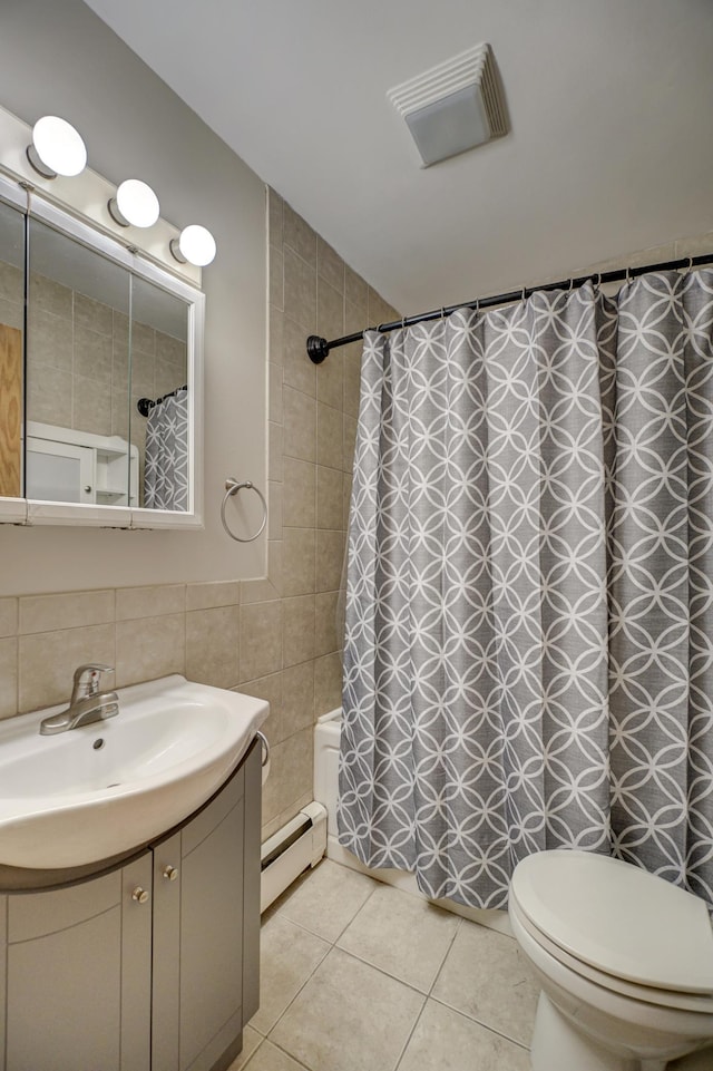 full bathroom featuring a baseboard radiator, vanity, tile walls, toilet, and tile patterned flooring