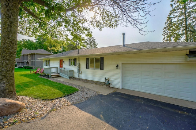 view of front of property featuring an attached garage, a front lawn, and driveway