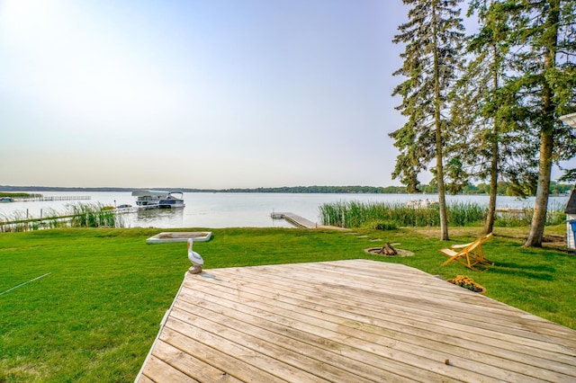 wooden deck featuring a boat dock, a yard, and a water view