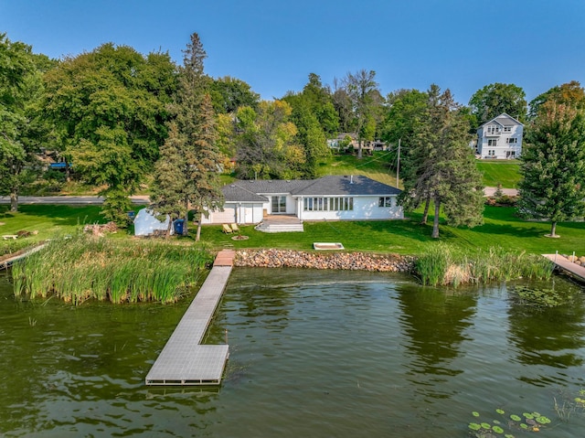 view of dock featuring a lawn and a water view
