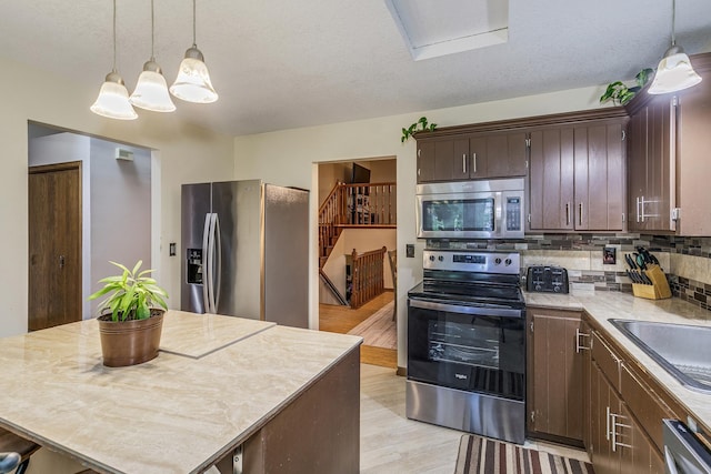 6645 Lancaster Ln N, Maple Grove, MN 55369 - kitchen with stainless steel appliances, dark brown cabinetry, backsplash, light countertops, and light wood finished floors