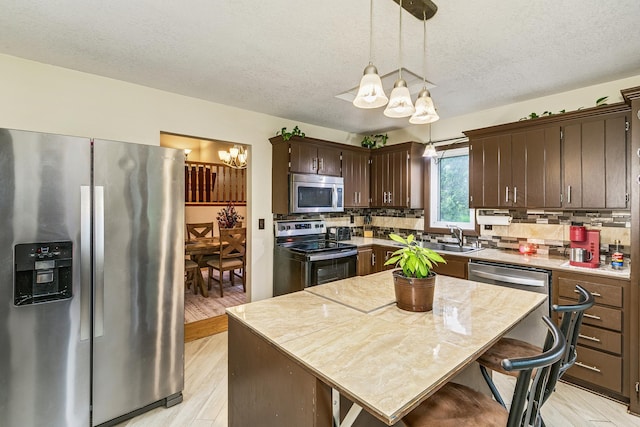 6645 Lancaster Ln N, Maple Grove, MN 55369 - kitchen featuring appliances with stainless steel finishes, a chandelier, dark brown cabinetry, tasteful backsplash, and a textured ceiling