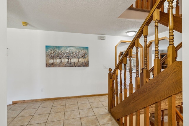 staircase featuring tile patterned floors and a textured ceiling