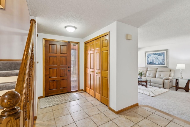 foyer with light carpet and a textured ceiling