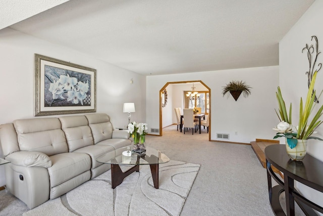 carpeted living room with a chandelier