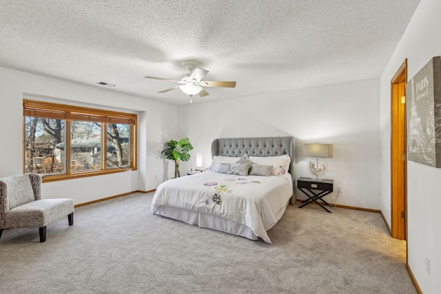 bedroom featuring light carpet, a textured ceiling, and ceiling fan