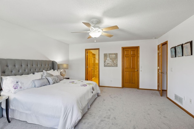 carpeted bedroom with connected bathroom, a textured ceiling, and ceiling fan