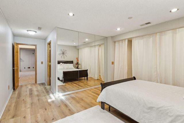 bedroom with hardwood / wood-style flooring and a textured ceiling