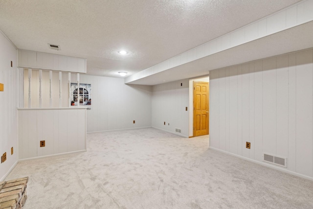 basement with light colored carpet and a textured ceiling