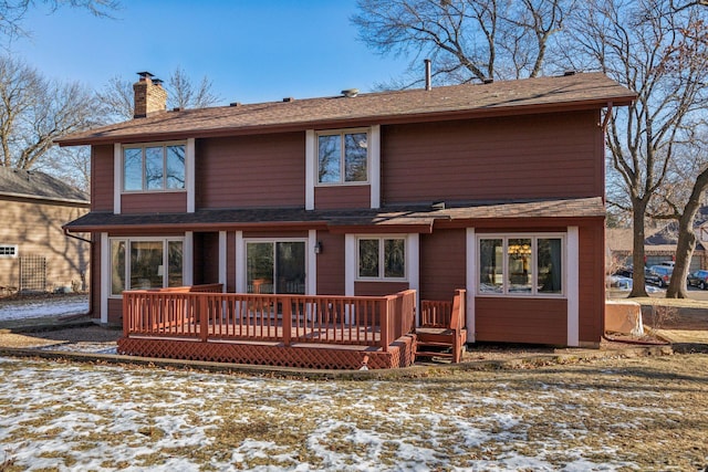 snow covered rear of property featuring a wooden deck