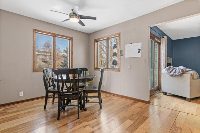 dining area with ceiling fan, light wood-type flooring, and baseboards